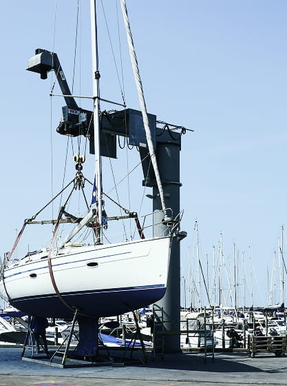Sailboat being lifted by a marine crane for maintenance at a boatyard — part of Zenith Eset’s yacht repair and inspection services